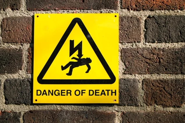 A yellow waring sign indicating danger of electric shock.