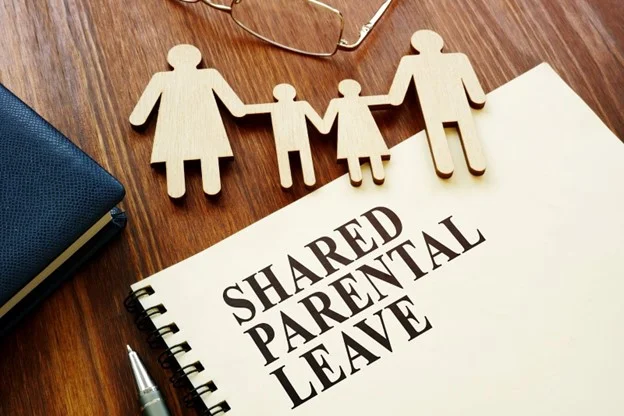 A shared parental leave policy on a desk, ready to be checked by an employment law specialist.