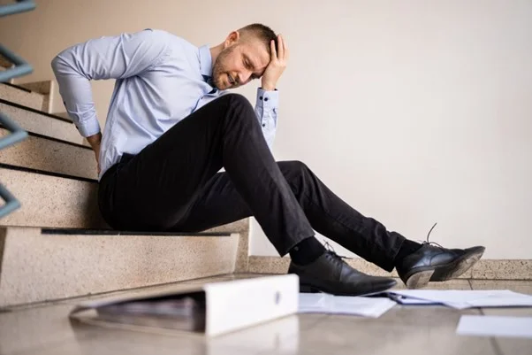 A person sitting on stairs with his head in his hand
