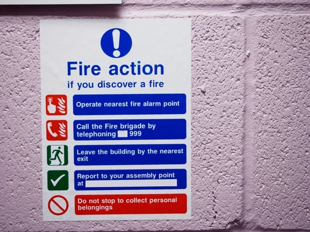 Fire action sign on the wall of a work premises. 