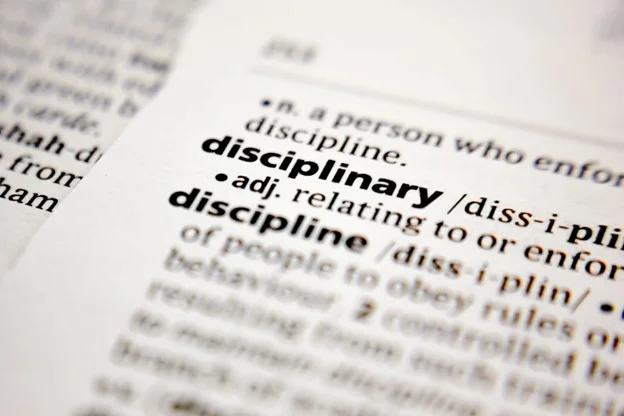 a close up of the dictionary definition on disciplinary highlighted. 