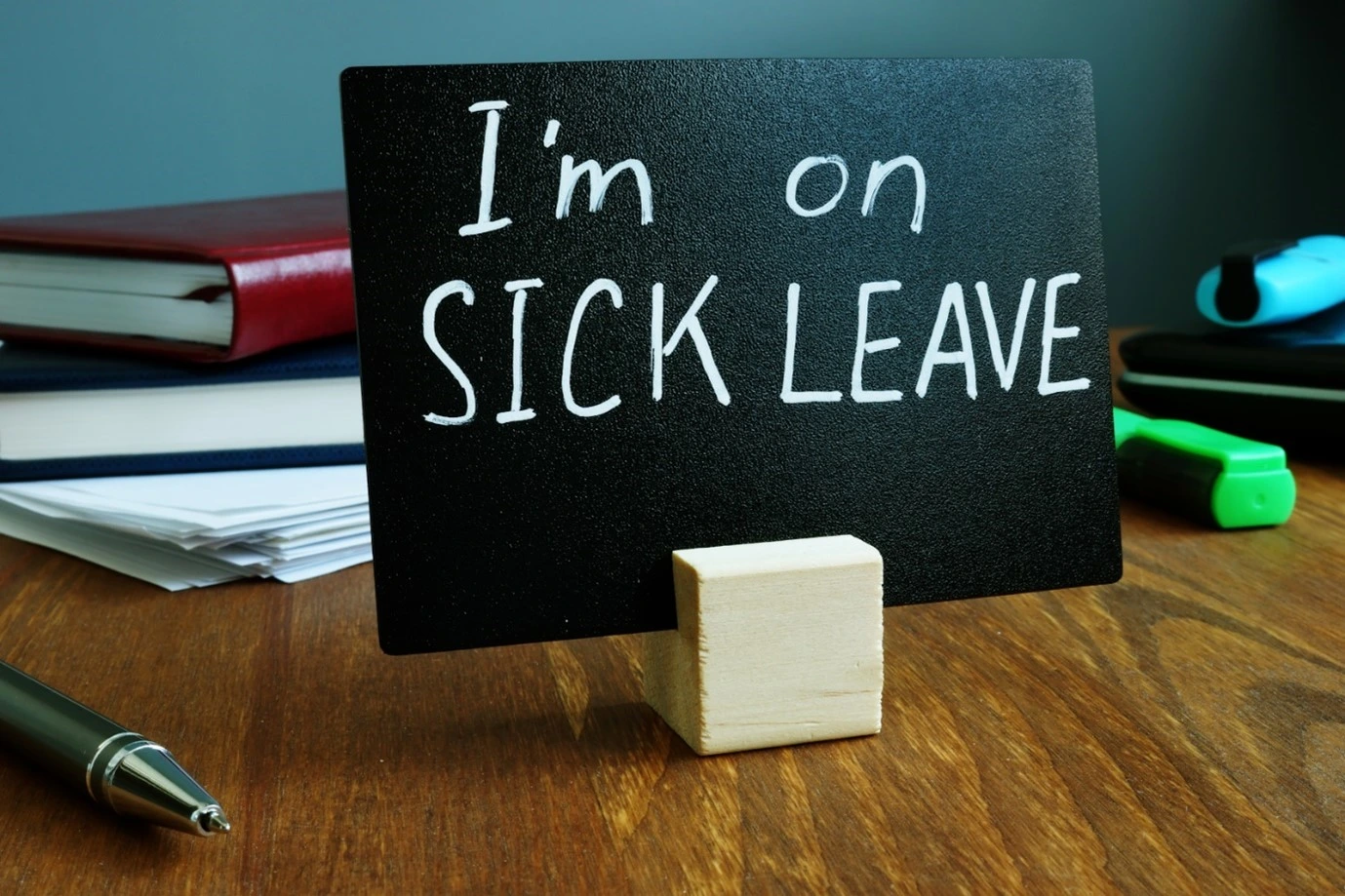 an employee who has gone on sick leave while putting a note on their desk.