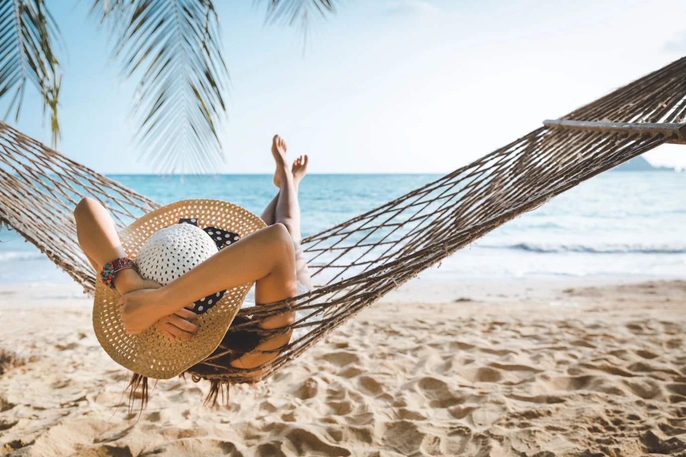 a lady having a rest on a hammock during the financial year on holiday
