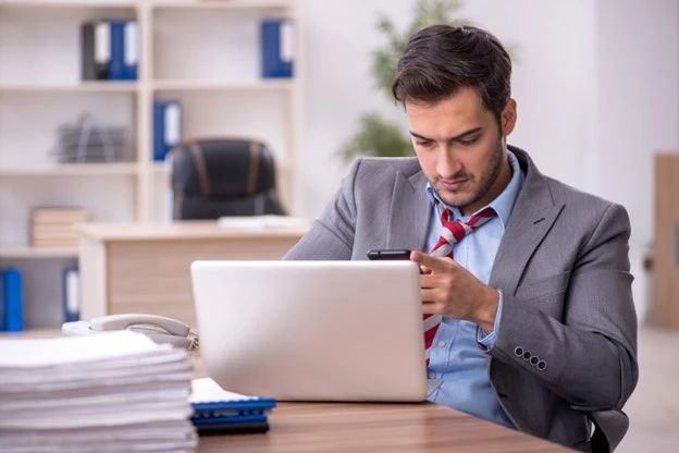 Male employee watching a tournament on phone whist researching sports event insurance