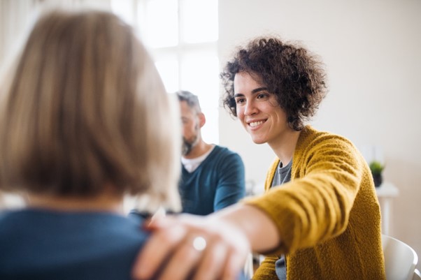 Photo of a woman offering mental health support to a colleague.