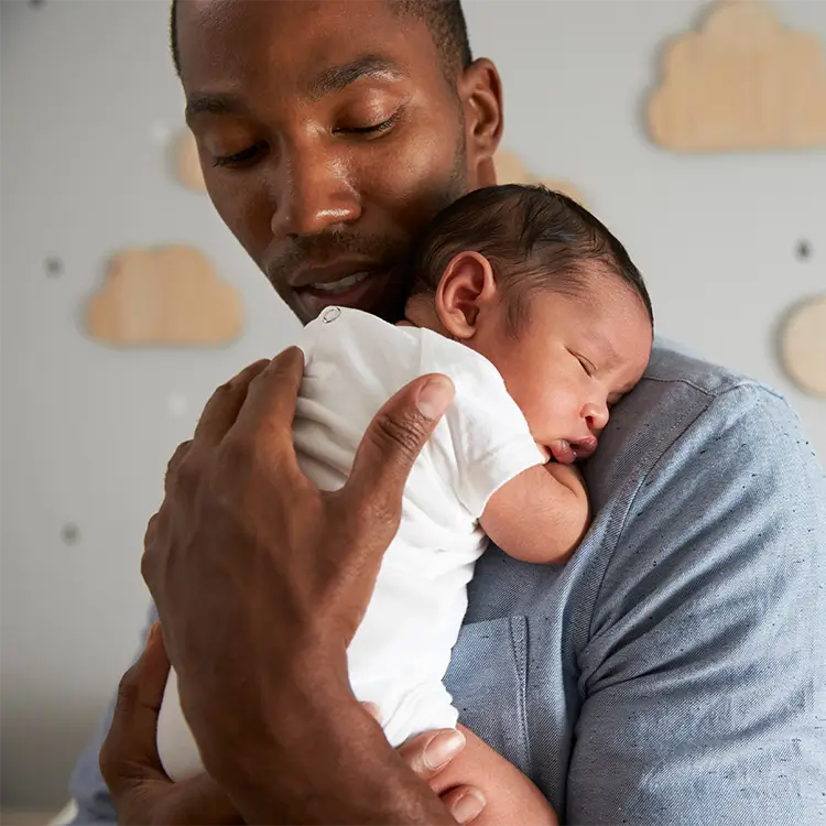 a man holding a child while on paternity leave