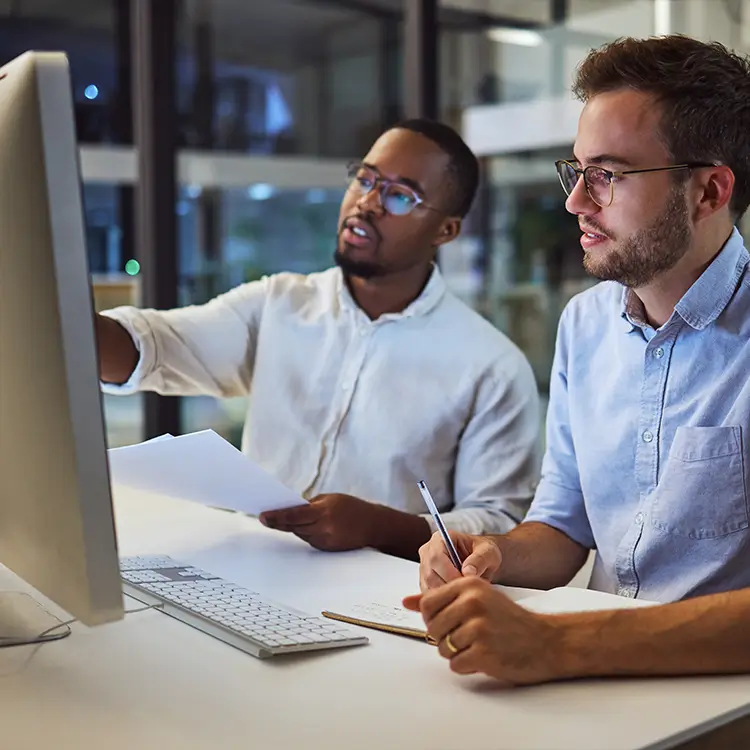 Two employees looking at a computer who are on zero hour contracts.